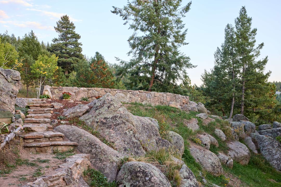 Stone steps leading through lush greenery and rocky terrain in a serene outdoor setting.