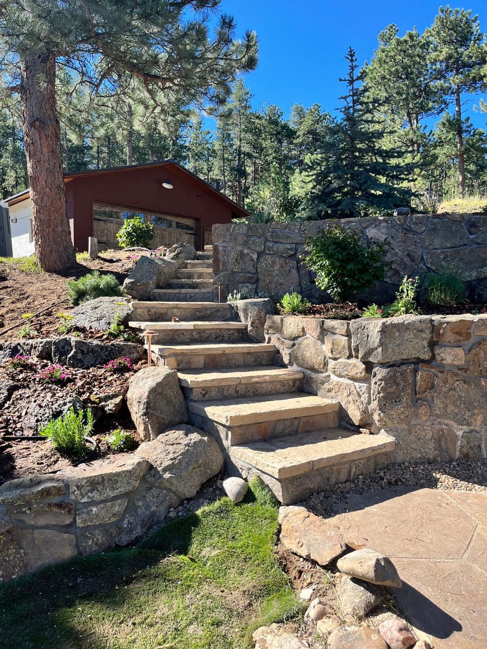 Scenic stone steps leading to a rustic cabin surrounded by trees and landscaped garden.