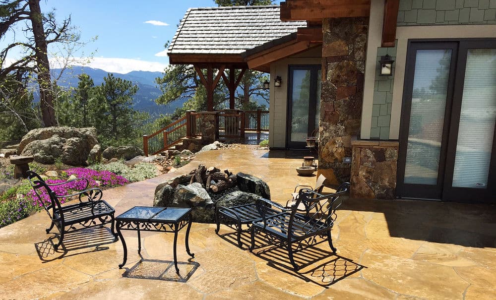 Mountain view patio with wrought iron furniture and stone fire pit. Ideal for outdoor relaxation.